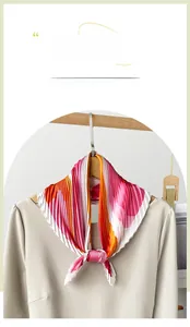 Detail view of an elegant pink and orange pleated satin scarf with a floral print