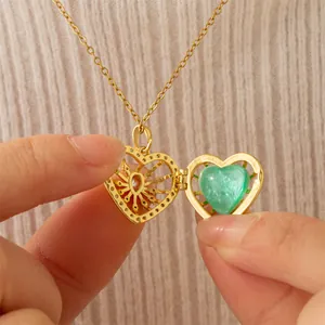 Gold heart-shaped locket necklace with green heart stone, opened to show details.