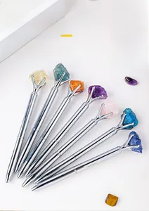Macro detail of various natural crystal stone toppers on silver metal ballpoint pens