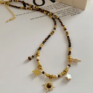 Bohemian sun flower pendant necklace featuring tiger eye beads and gold star charms.