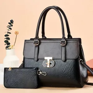 Elegant black faux leather handbag set with gold buckle detail and matching pouch accessory