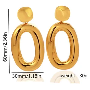 Close-up detail of chunky gold oval hoop earrings with size and weight markers