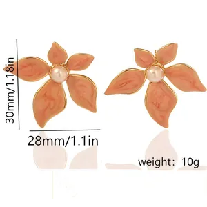 Detailed macro view of oversized gold-plated flower earrings featuring a pearl center