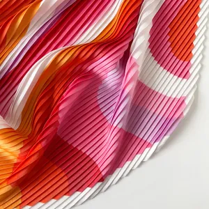 Detailed close-up of pleated satin scarf with vibrant geometric pink and orange patterns