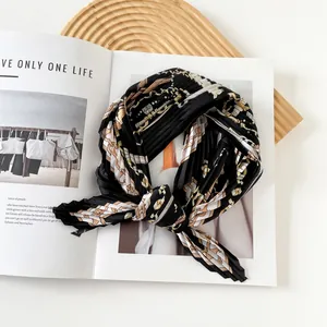Detailed view of elegant black pleated satin scarf with golden chain print patterns