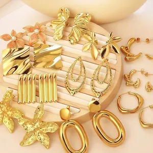 Exaggerated geometric gold-plated earring collection displayed on a wooden stand