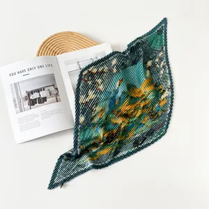 Close-up of artistic oil painting style pleated silk scarf with emerald green print
