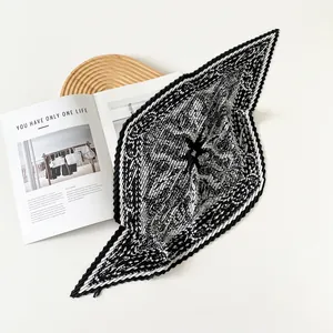Close-up of pleated silk scarf with black and white vintage print on satin fabric