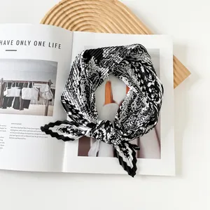 Detail showing the intricate pleated texture of a black and white printed scarf.