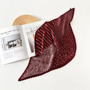 Detail view of a 70cm pleated maroon silk scarf with paisley and polka dot patterns.