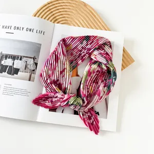 Close-up of pleated floral pink silk scarf on a lifestyle magazine