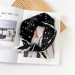 Detailed view of 70cm black pleated square silk scarf with white polka dots pattern