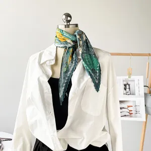 Close-up detail of a pleated floral satin scarf styled on a classic white shirt neck