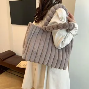 Grey plush tote bag with pom-pom handles and ribbed faux fur texture for winter