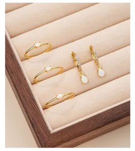 Detailed shot of gold-plated s925 silver opal rings and drop earrings set in jewelry box