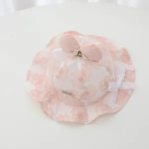 Close-up of baby lace sun hat featuring delicate floral embroidery and a pink bow