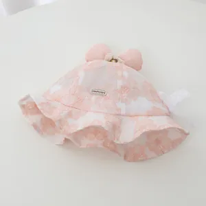 Detailed view of pink lace baby girl bucket hat with floral pattern and bow