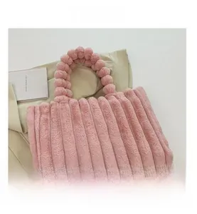 Detail of soft pink plush tote bag with thick fur texture and sturdy handle