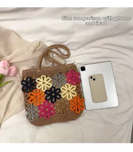 Handmade straw tote bag with colorful flower patterns shown next to a tablet for size.