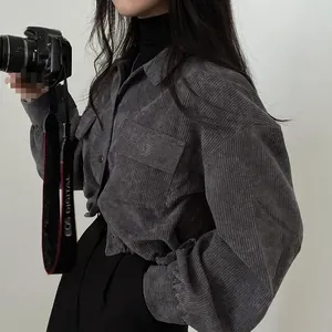 Close-up of grey corduroy button-up shirt with front pocket and elastic cuffs