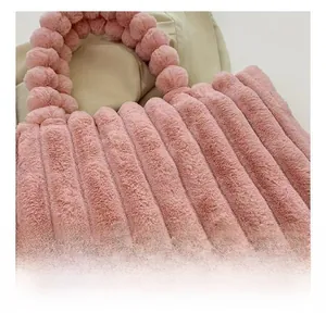 Macro detail of a pink plush tote bag showing soft ribbed faux fur fabric texture