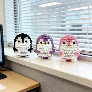 Handmade crochet positive penguins in black, purple and pink holding inspirational cards