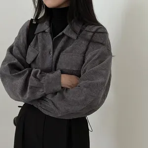 Detail shot of a women's vintage grey corduroy shirt with lapels and button pockets