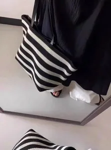 High-quality large black and white striped woven tote bag shown in a mirror reflection