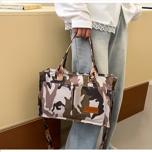 Stylish large capacity camouflage print tote bag with front pockets held by model