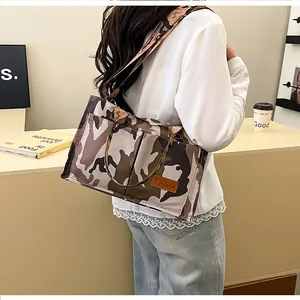 Macro view of a stylish large capacity camouflage shoulder bag with brown leather patch
