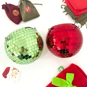 Detailed view of red and green mirror disco ball hanging planters with festive holiday props