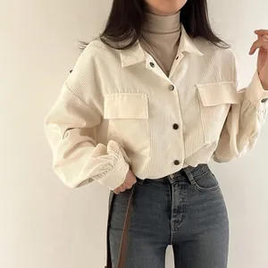 Close-up detail of a vintage off-white corduroy shirt jacket styled with blue jeans