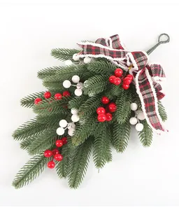 Close-up of Christmas pine teardrop swag with red berries and plaid bow detail.