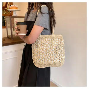 Detailed shot of a cream straw woven tote bag featuring an elegant flower hollow design