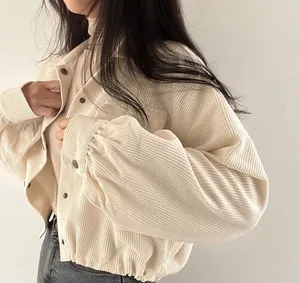 Detail of beige corduroy jacket with puff sleeves and button-down front for women.