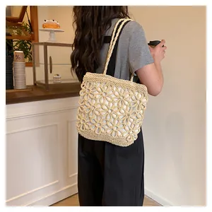 Detail of hand-woven straw tote bag with an elegant floral hollow-out pattern