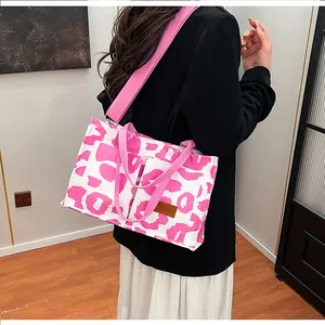 Detail view of large pink cow print tote bag worn over the shoulder