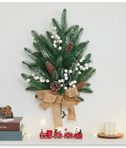 Decorative Christmas wall hanging with pine cones, white berries, and a burlap bow.