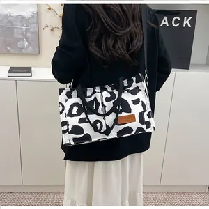 Detailed view of a stylish large capacity black and white leopard print shoulder bag