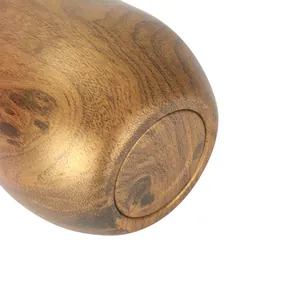 Detailed view of the wood grain texture on the bottom of a 12oz stainless steel tumbler