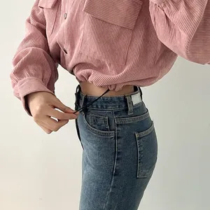 Detail of pink corduroy shirt jacket showing adjustable drawstring hem and fabric texture.