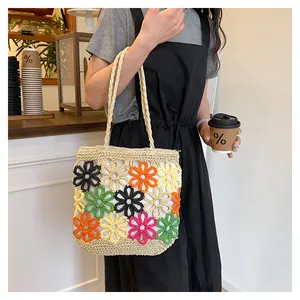 Close-up detail of a colorful floral pattern woven tote bag held by a female model