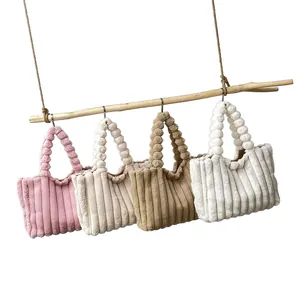 Autumn plush tote bags with unique bubble handles in four colors hanging from a branch