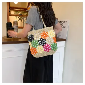 Vibrant colorful floral crochet tote bag shown on shoulder in a cozy cafe setting