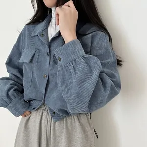 Close-up of blue corduroy jacket showing ribbed texture and drawstring detail.