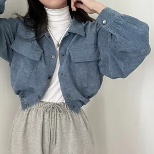 Detailed view of a retro blue corduroy cropped jacket featuring button accents