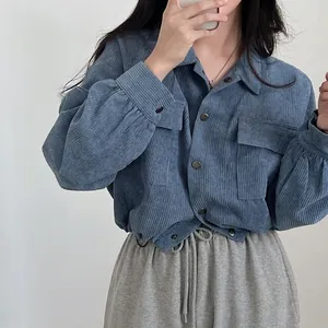 Detail of a blue corduroy cropped shirt with drawstring hem and lantern sleeves.