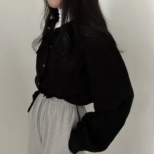 Detailed side view of chic black corduroy cropped drawstring shirt jacket on a model