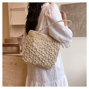 Elegant hand-woven straw tote bag with delicate floral hollow pattern for summer style