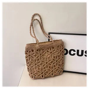 Detailed view of large capacity woven straw tote bag with elegant hollow flower patterns